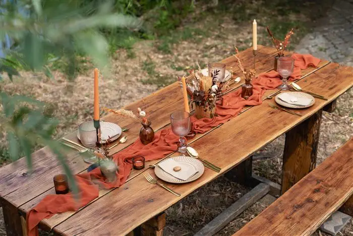 Boho stílusú, terrakotta esküvői asztal zászlófüzérrel a háttérben